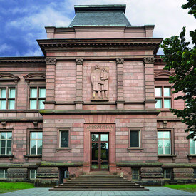 Der Haupteingang des Rheinischen Landesmuseums Trier mit seiner historischen Sandsteinfassade und dem markanten Eingangsportal.