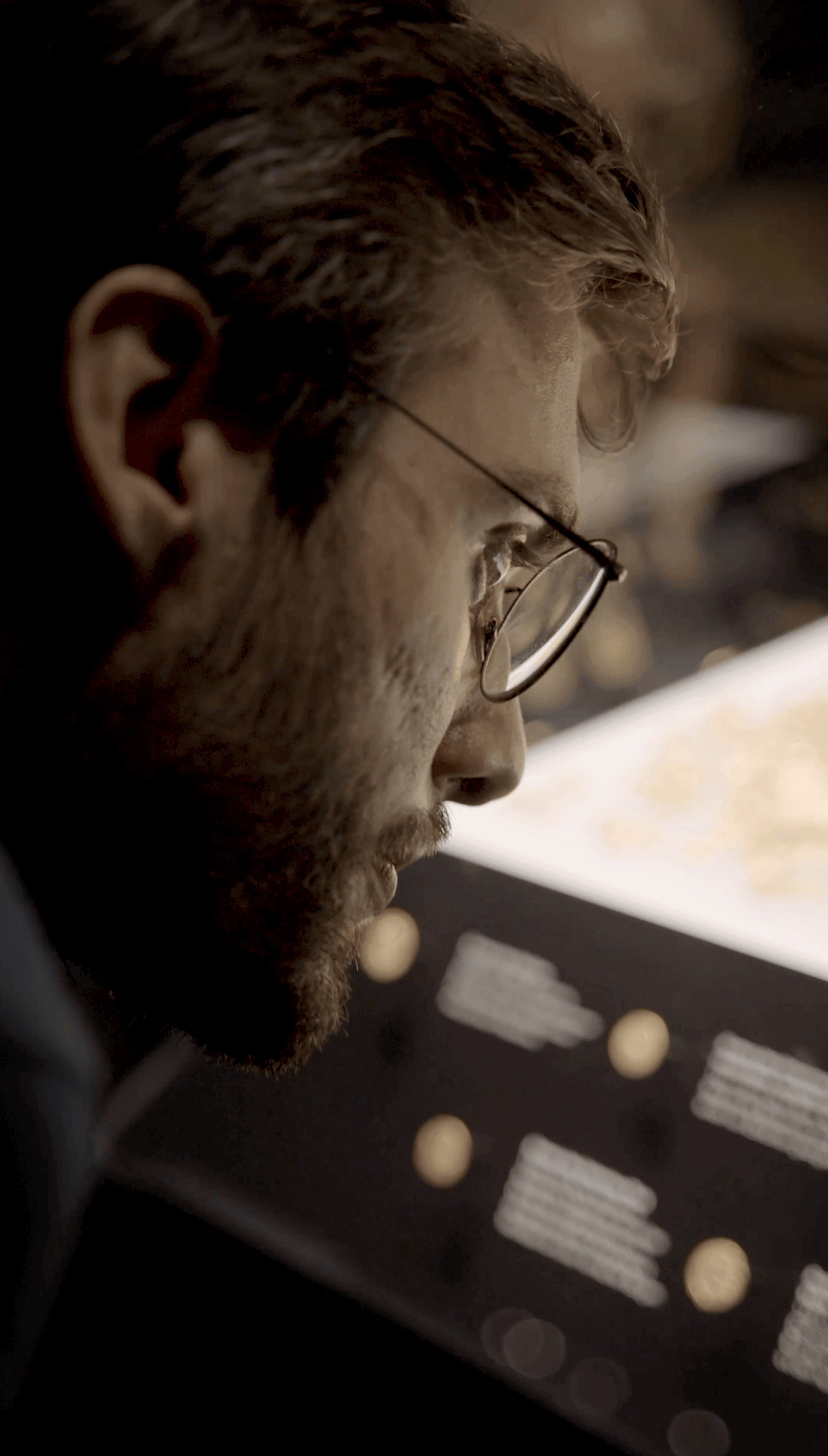 Ein Besucher betrachtet eine Ausstellung in der Schatzkammer der Stadtbibliothek Trier an einer interaktiven Informationsstation.